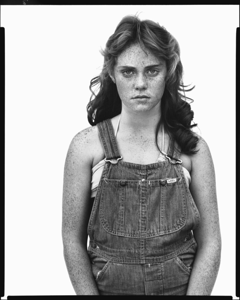 Retrato en blanco y negro de una joven con pecas y overol