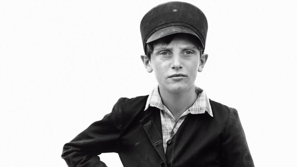Retrato en blanco y negro de un niño con gorra y chaqueta