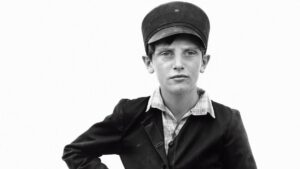 Retrato en blanco y negro de un niño con gorra y chaqueta