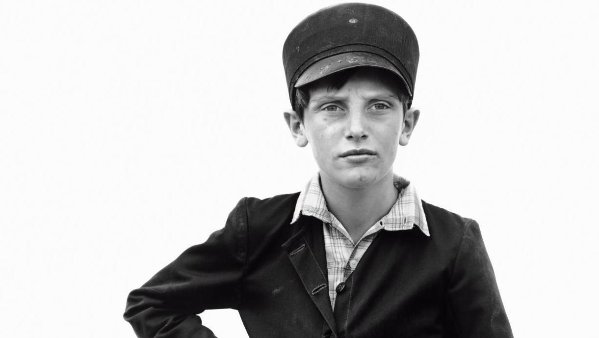 Retrato en blanco y negro de un niño con gorra y chaqueta