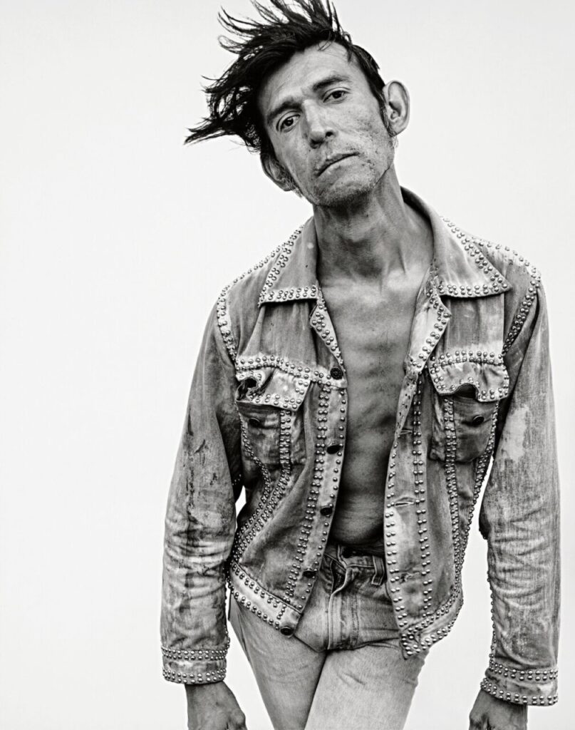 Retrato en blanco y negro de un hombre con chaqueta decorada.