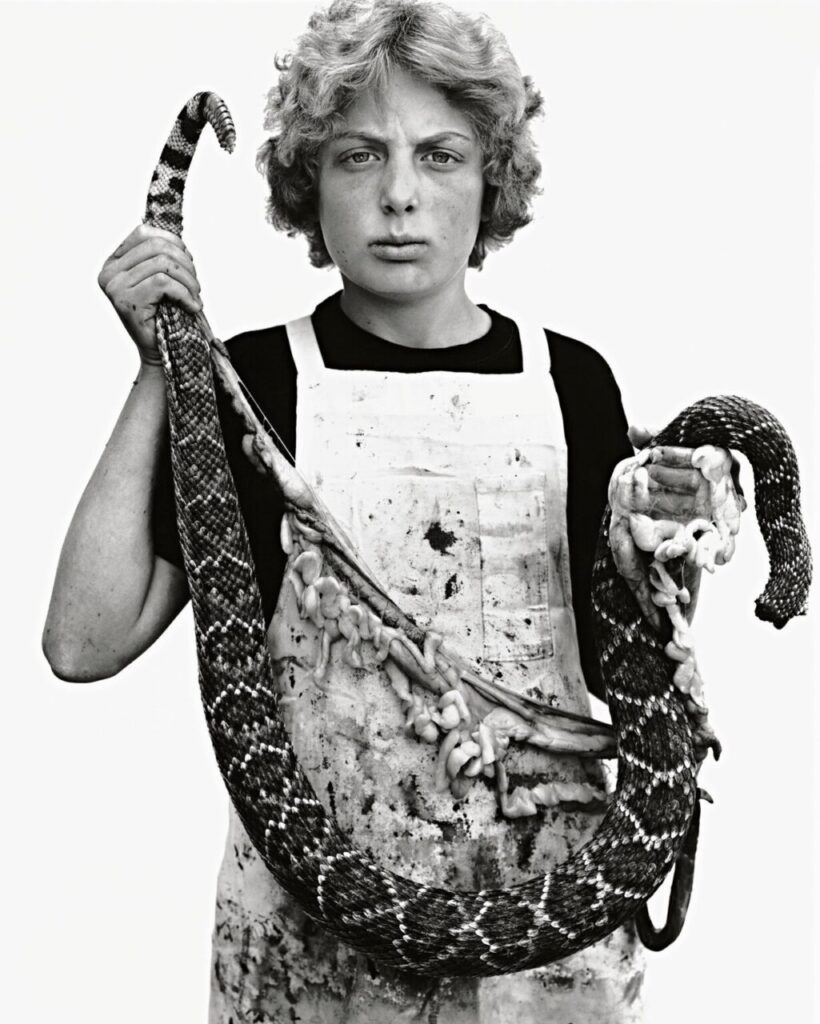 Retrato en blanco y negro de un niño sosteniendo una serpiente