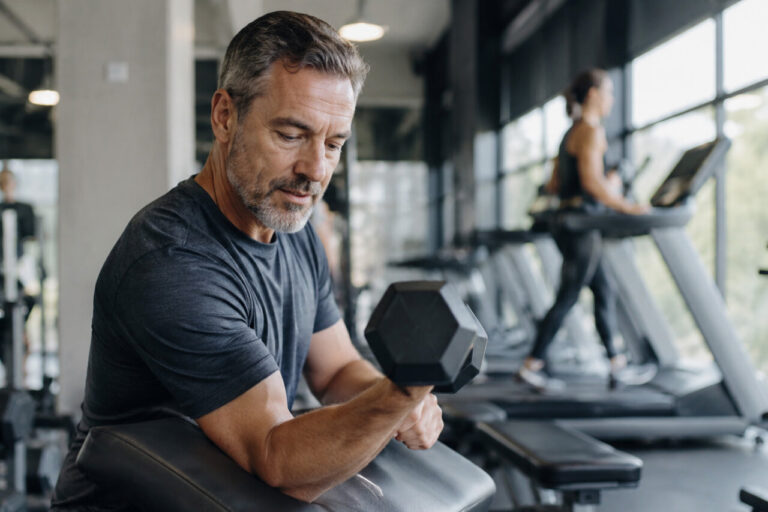 Hombre levantando pesas en un gimnasio durante entrenamiento de fuerza