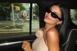 Mujer con gafas oscuras sonriendo en un coche