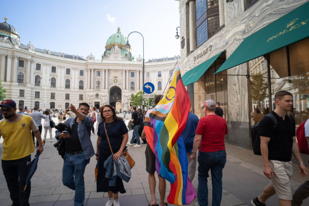 Personas marchando con bandera del orgullo en Viena