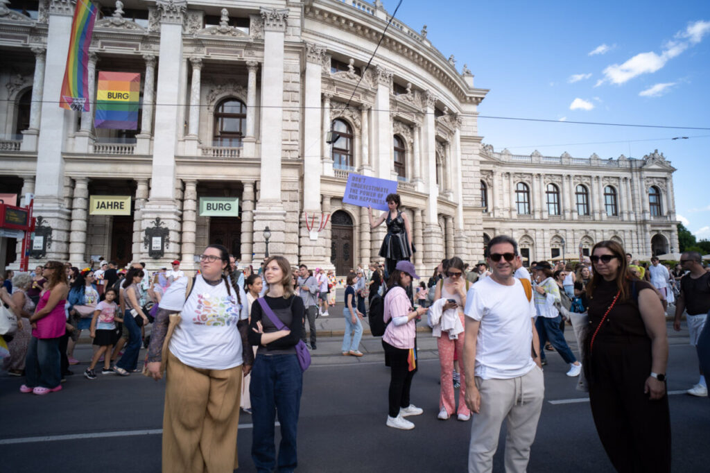 Multitud en la marcha del Orgullo en Viena con banderas y pancartas.