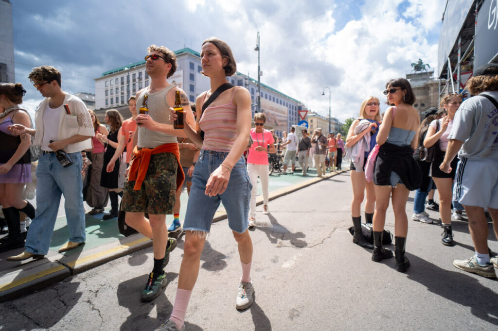 Personas participando en la marcha del Orgullo en Viena bajo un cielo nublado.