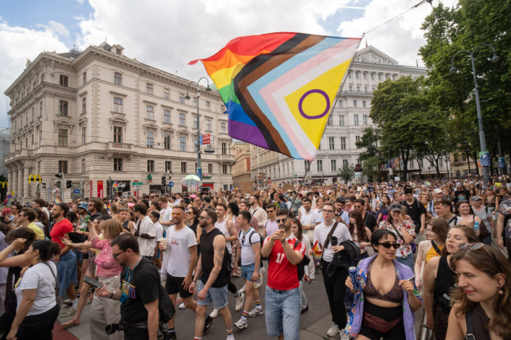 Multitud en la marcha del Orgullo en Viena con bandera inclusiva