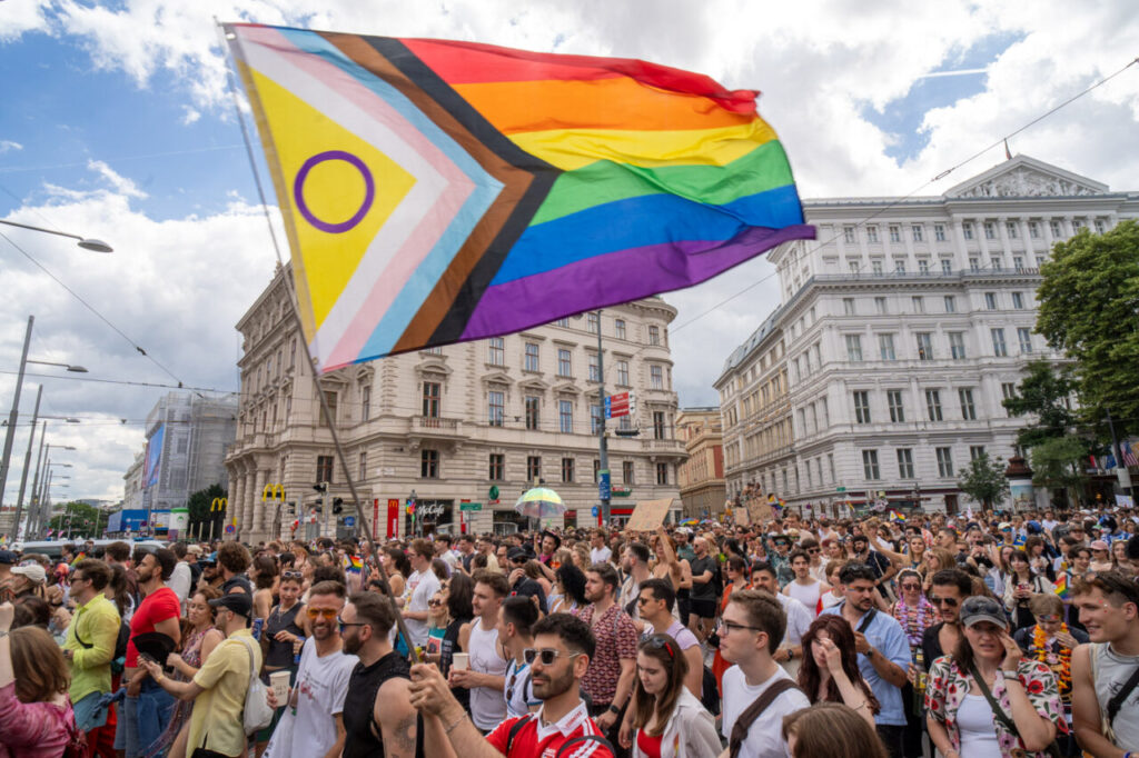 Multitud de personas en la marcha del Orgullo en Viena con bandera arcoíris