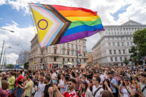 Multitud de personas en la marcha del Orgullo en Viena con bandera arcoíris