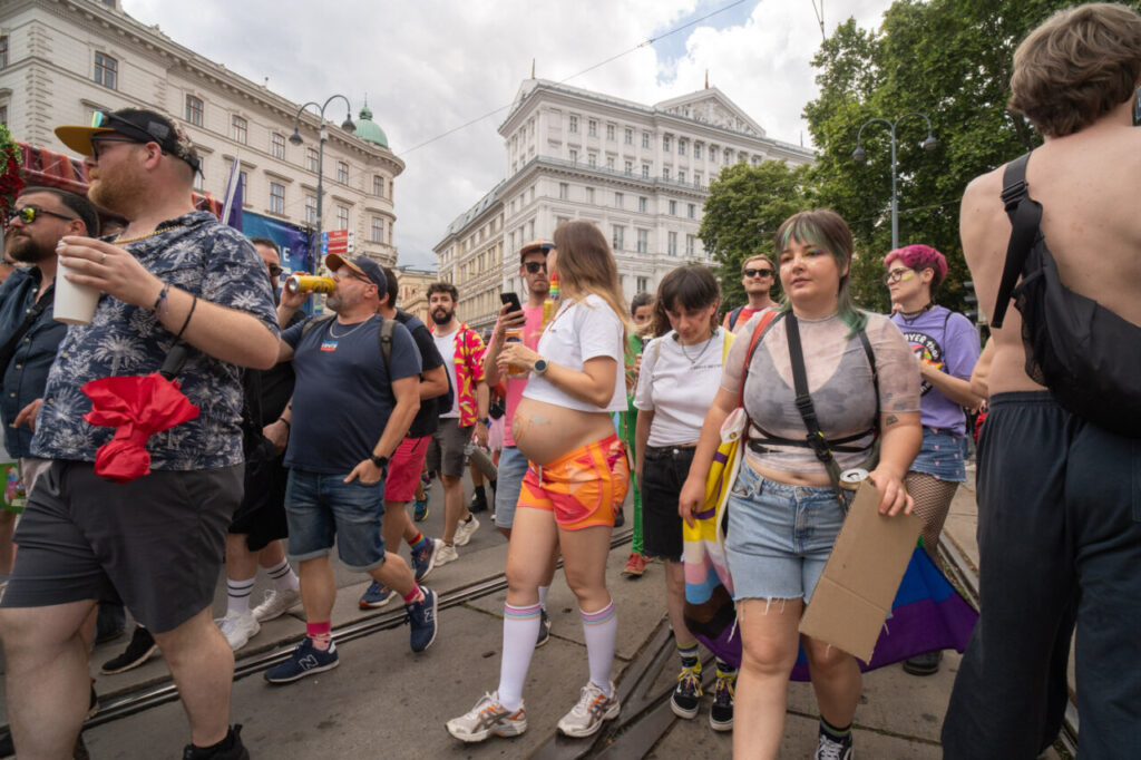 Participantes de la marcha del Orgullo en Viena con banderas y atuendos coloridos
