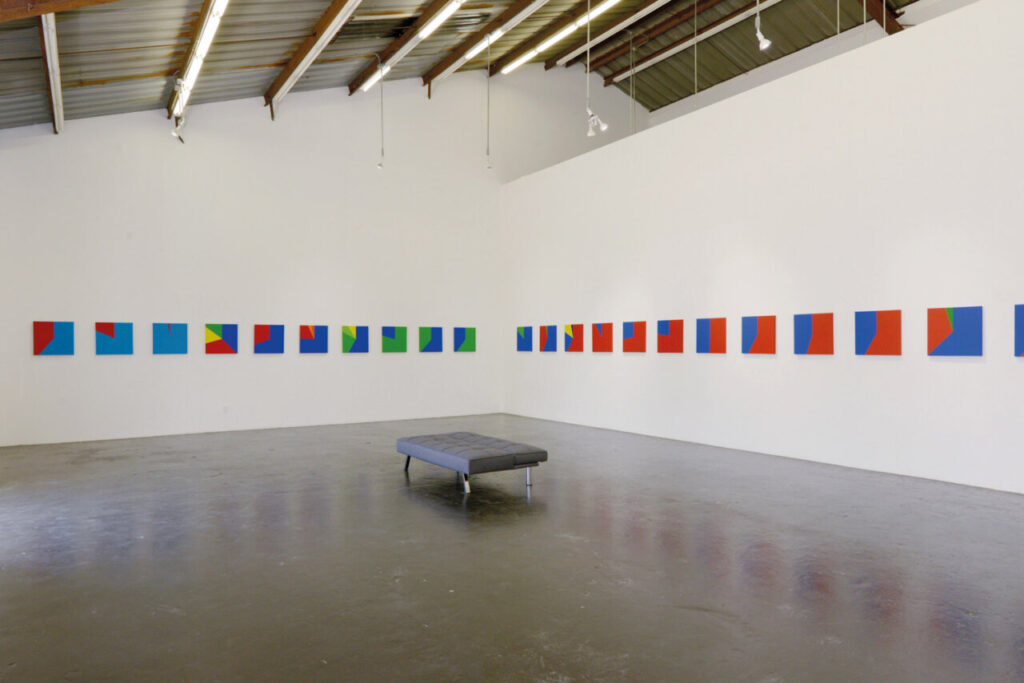 Exposición de arte contemporáneo con obras coloridas en las paredes.