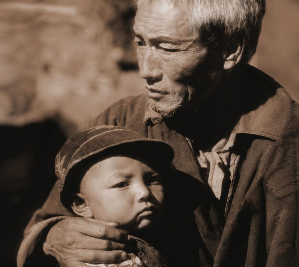 Retrato de un abuelo sosteniendo a su nieto en blanco y negro