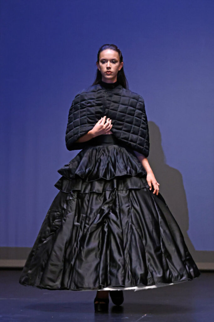 Jóvenes Diseñadores de Baleares inaugura su edición rumbo a la gala nacional 21 Modelo en pasarela con vestido negro y capa en gala de ANDE