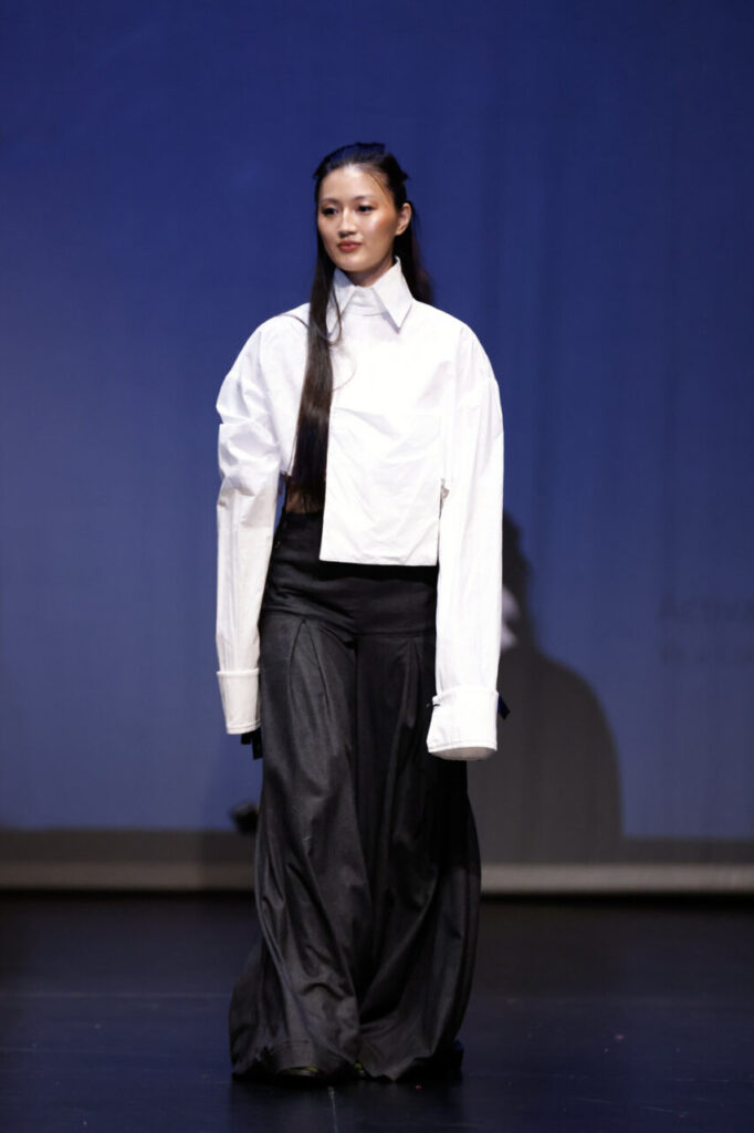 Jóvenes Diseñadores de Baleares inaugura su edición rumbo a la gala nacional 17 Modelo caminando en pasarela con camisa blanca y pantalones oscuros