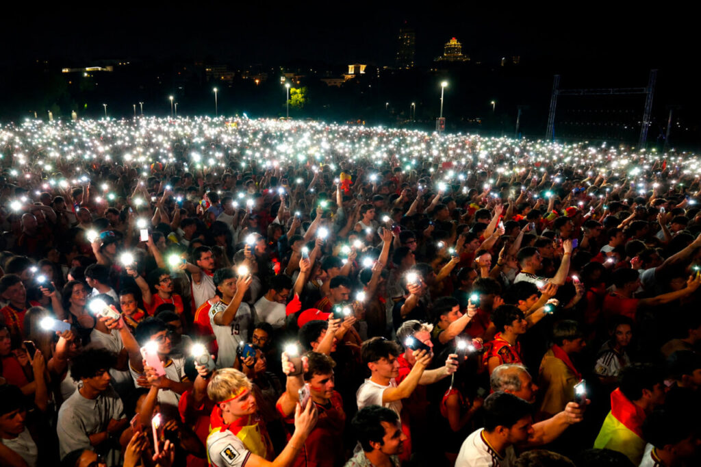 Multitud de aficionados con teléfonos encendidos en un evento futbolístico