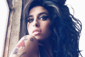 Retrato de Amy Winehouse con cabello rizado y tatuajes visibles