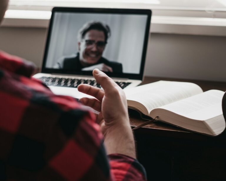 Persona participando en una clase virtual a través de un ordenador portátil