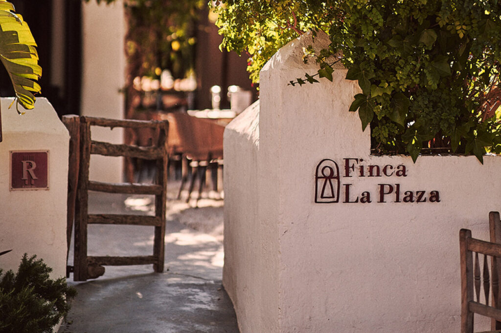 Entrada a Finca La Plaza con vegetación y señalización