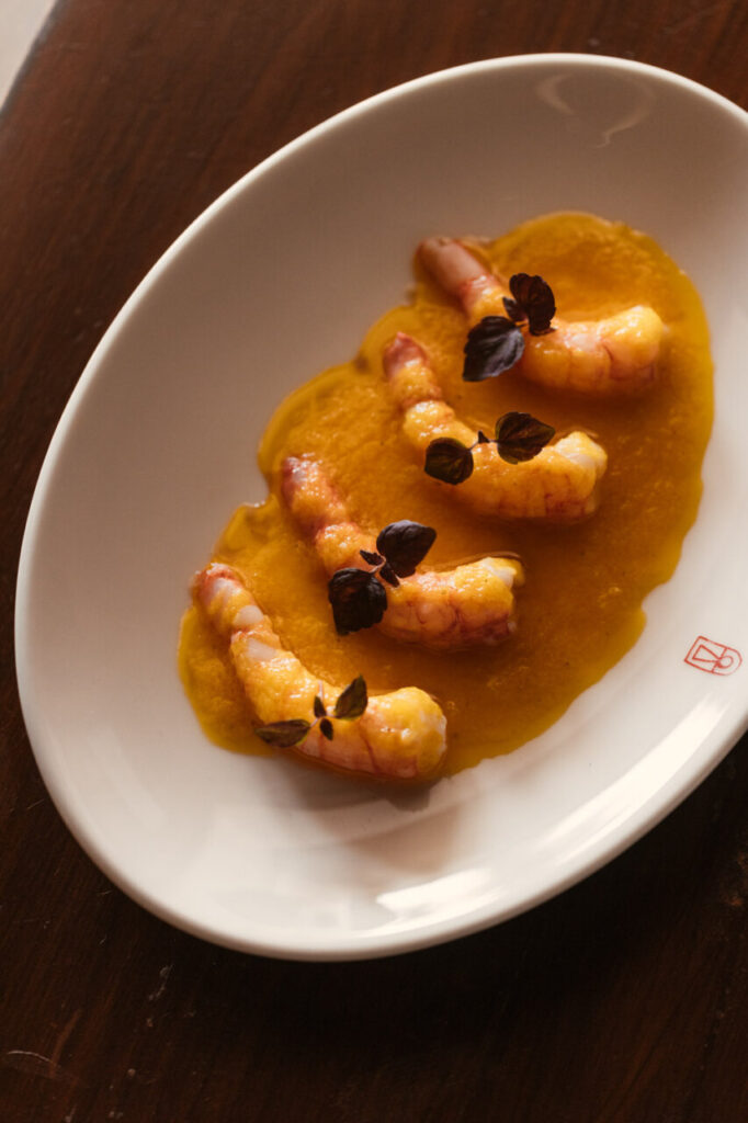 Finca La Plaza: la finca de casi tres siglos que cocina la Ibiza más auténtica 3 Plato gourmet con langostinos sobre salsa amarilla en Finca La Plaza