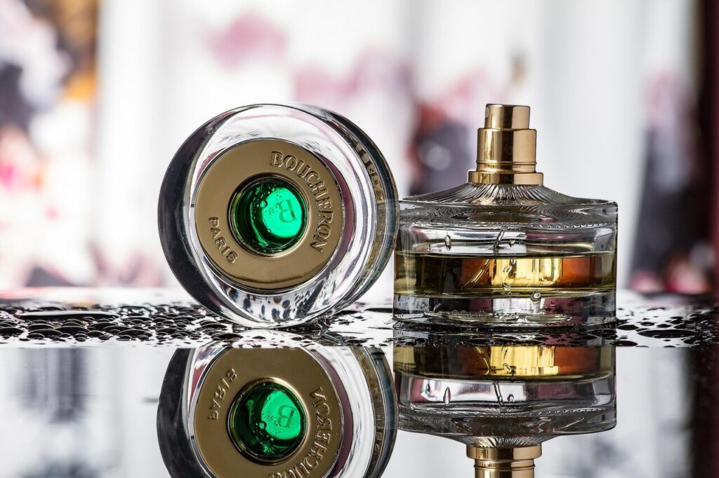 Botellas de perfume sobre una superficie reflectante con fondo desenfocado.