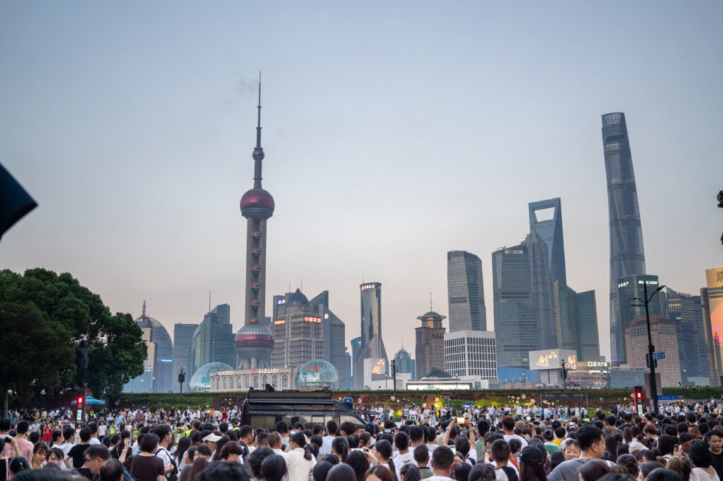 Multitud de personas en Shanghai con rascacielos de fondo